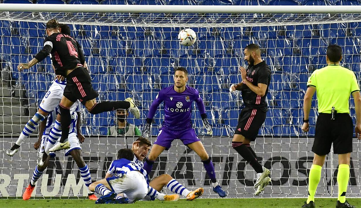 Bek Real Madrid, Sergio Ramos, menyundul bola saat melawan Real Sociedad pada laga Liga Spanyol di Stadion Anoeta, Minggu (20/9/2020). Kedua tim bermain imbang 0-0. (AP/Alvaro Barrientos)