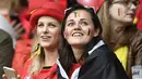 Fans cantik Belgia tengah serius menanti laga antara timnya melawan Wales pada perempat final Piala Eropa 2016 di Stade Pierre-Mauroy, Lille, Prancis, Sabtu (2/7/2016) dini hari WIB. (AFP/Miguel Medina)