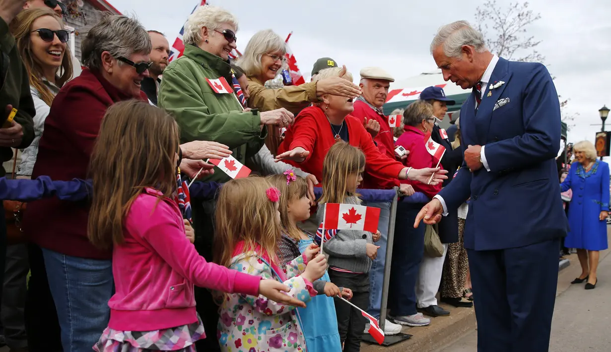Pangeran Charles menyapa sejumlah anak-anak yang ikut menyambut kedatangannya bersama sang Istri, Camilla dalam kunjungannya ke Kanada, Senin (19/5/14). (REUTERS/Mark Blinch)