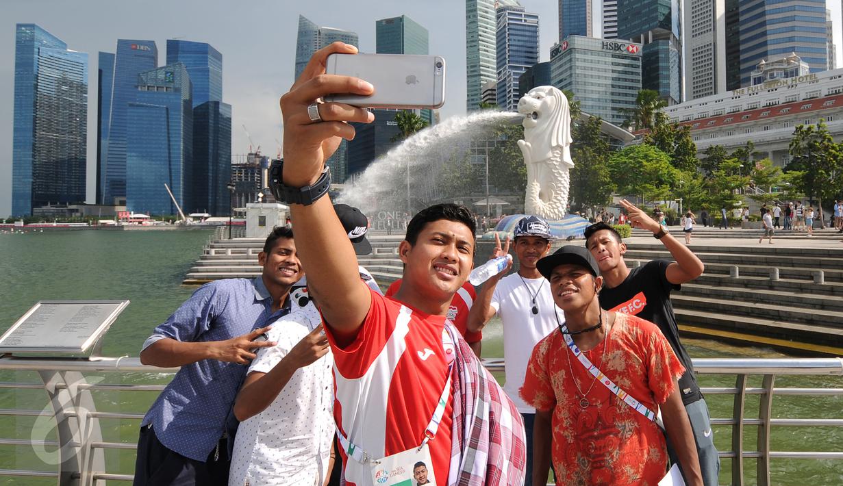 Para pemain timnas Indonesia U-23 ber-selfie di Merlion Park, Singapura, Jumat (5/6/2015). Para penggawa Garuda Muda bersantai sejenak usai melaksanakan ibadah salat Jumat di Masjid Sultan, Bugis, Singapura. (Liputan6.com/Helmi Fithriansyah)