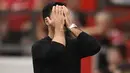 Ekspresi pelatih Arsenal, Mikel Arteta yang menutup wajahnya sebagai reaksi dari kekalahan timnya saat bertandang ke Markas Manchester United dalam pertandingan pekan keenam Liga Inggris 2022/2023. (AFP/Oli Scarff)