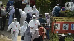 Suasana pelaksanaan swab test terhadap warga di Balai RW 20, Villa Dago, Pamulang, Tangerang Selatan, Banten, Jumat (17/7/2020). Swab test gratis yang dilakukan seiring meningkatnya kasus COVID-19 tersebut diikuti 200 warga dari beberapa RW di Benda Baru. (merdeka.com/Dwi Narwoko)
