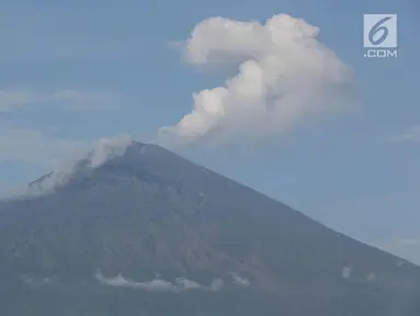 Asap tebal keluar dari puncak kawah Gunung Agung terlihat dari kawasan Amed, Karangasem, Bali, Kamis (7/12). Sepekan terakhir, aktivitas kawah Gunung Agung mulai tampak tenang, meskipun masih dalam status Awas. (Liputan6.com/Immanuel Antonius)