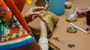 Pekerja menjahit baju untuk wayang kayu khas Sunda atau wayang golek di galeri kerajinan tangan Cupumanik di Bandung, 17 Februari 2020. Galeri kerajinan tangan Cupumanik memproduksi berbagai wayang golek untuk dijual sebagai cendera mata bagi wisatawan lokal maupun asing. (Xinhua/Septianjar)