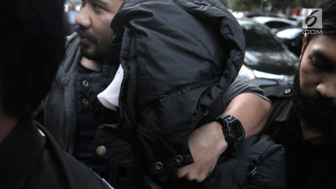 Tersangka kasus pembunuhan suami dan anak tiri, Aulia Kesuma menutupi wajah dengan jaket saat tiba di Mapolda Metro Jaya, Jakarta, Kamis (29/8/2019).  Aulia melakukan pembunuhan berencana di kediaman Pupung di Lebak Bulus dan jasadnya dibakar di Sukabumi. (merdeka.com/Iqbal S. Nugroho)