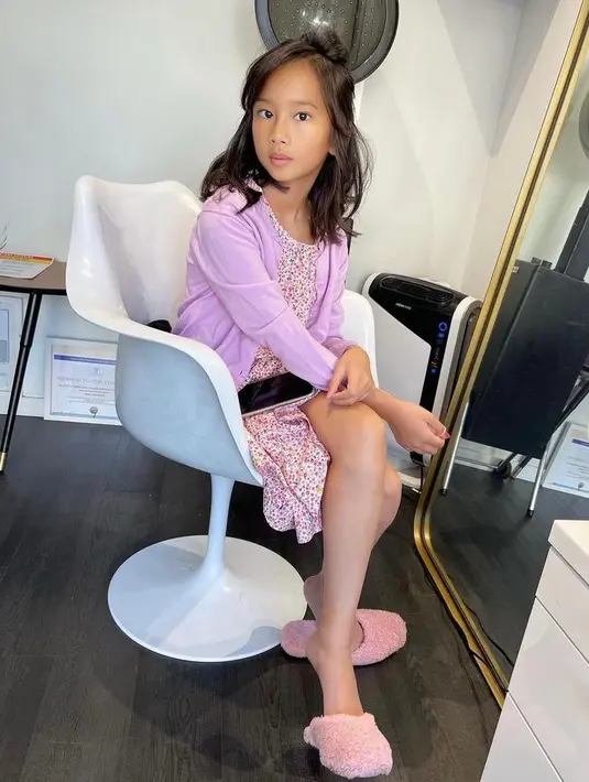 Meski baru berusia 12 tahun, wajah cantik Kierra sudah jelas terlihat. Seperti potret ini, Kierra tampil modis berbalut dress, cardigan ungu, serta sandal berbulu. (Instagram/adindabakrie).