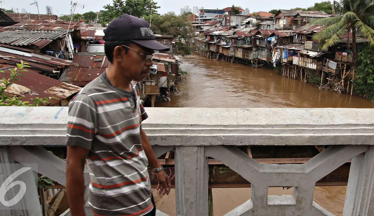 Warga berjalan dijembatan bantaran Kali Ciliwung, Jakarta, Rabu (20/1). Apabila rusun yang disediakan telah siap ditempati Pemprov DKI Jakarta akan melakukan penggusuran pemukiman kumuh sebanyak mungkin. (Liputan6.com/Immanuel Antonius)