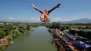 Penonton menyaksikan dari tepi sungai saat seorang peserta melakukan terjun bebas dari jembatan Ura e Shejnt dalam kompetisi menyelam tradisional ke-68 di Gjakova, Kosovo, 22 Juli 2018. Kompetisi ini dilakukan dari ketinggian 22 meter. (AP/Visar Kryeziu)