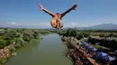 Penonton menyaksikan dari tepi sungai saat seorang peserta melakukan terjun bebas dari jembatan Ura e Shejnt dalam kompetisi menyelam tradisional ke-68 di Gjakova, Kosovo, 22 Juli 2018. Kompetisi ini dilakukan dari ketinggian 22 meter. (AP/Visar Kryeziu)