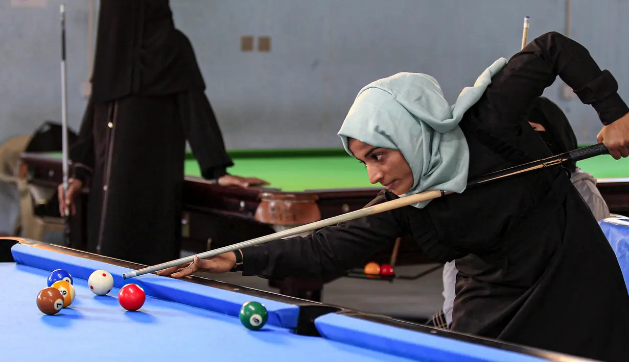 Seorang wanita membidik bola saat mengikuti kejuaraan biliar lokal di sebuah gedung olahraga di ibu kota  Sanaa, Yaman  (16/12/2019).  (AFP/Mohammed Huwais)