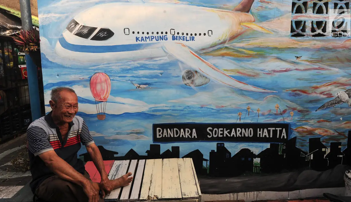 Warga nongkrong di depan gambar mural/grafiti yang ada di Kampung Bekelir, Jalan Perintis Kemerdekaan, Kota Tangerang, Banten, Selasa (17/4). Kampung Bekelir pada 10 tahun lalu merupakan kawasan yang kumuh. (Merdeka.com/Arie Basuki)