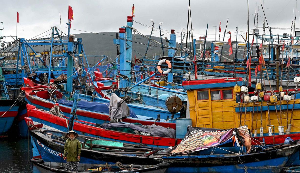 Seorang wanita memandang dari perahu kecil saat orang-orang mempersiapkan kapal penangkap ikan untuk menghadapi dampak Topan Kalmaegi di Pelabuhan Ikan Quy Nhon, Provinsi Gia Lai, Vietnam Tengah, pada 6 November 2025. (Nhac NGUYEN/AFP)