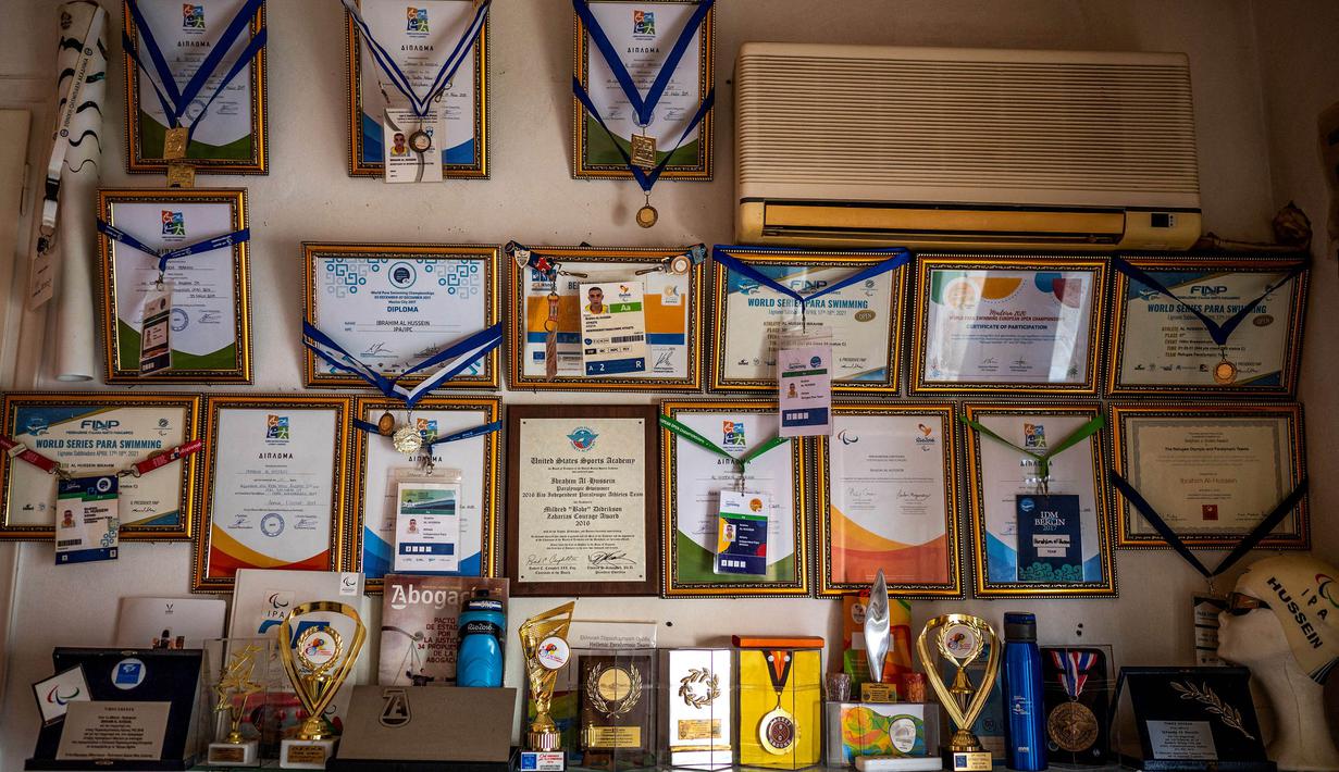 Deretan medali yang terpajang di dinding tempat tinggalnya di Athena ini menjadi saksi perjuangannya. Komite Olimpiade Helenic mulai menaruh perhatian ke al-Hussein ketika ia memenangkan kompetisi disabilitas Yunani dan memilihnya untuk membawa obor Olimpiade Rio 2016. (Foto: AFP/Angelos Tzortzinis)