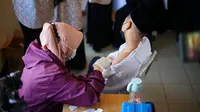 Nampak sejumlah santri di pesantren Al-Masduqiyah tengah melaksanakan vaksinasi di lingkungan pesantren di Garut, Jawa Barat. (Liputan6.com/Jayadi Supriadin)