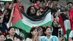 Seorang suporter membentangkan bendera Palestina saat laga Grup B Kualifikasi Piala Dunia 2026 antara Korea Selatan melawan Palestina di Seoul World Cup Stadium, Seoul, Korea Selatan, Kamis (05/09/2024) WIB. (AFP/Jung Yeon-je)