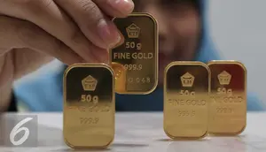 Petugas menunjukan emas batangan di kantor BNI Syariah, Jakarta, Senin (30/11). Harga jual-beli kembali (buyback) emas Antam turun Rp 1.000 usai akhir pekan kemarin naik di tengah turunnya harga emas global. (Liputan6.com/Angga Yuniar)