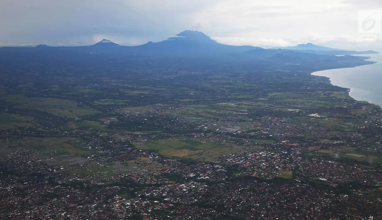 Landskap Gunung Agung terlihat dari udara, Bali, Kamis (30/11). Asap yang dikeluarkan dominan putih dan tidak berwarna abu kegelapan seperti hari-hari sebelumnya. (Liputan6.com/Immanuel Antonius)