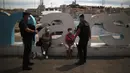 Polisi anti huru-hara Prancis berbincang dengan warga yang mengenakan masker di Marseille, Selasa (18/8/2020). Prancis mengirim polisi anti huru hara ke wilayah Marseille untuk membantu menegakkan peraturan penggunaan masker saat negara itu mencatat lonjakan kasus COVID-19. (AP Photo/Daniel Cole)