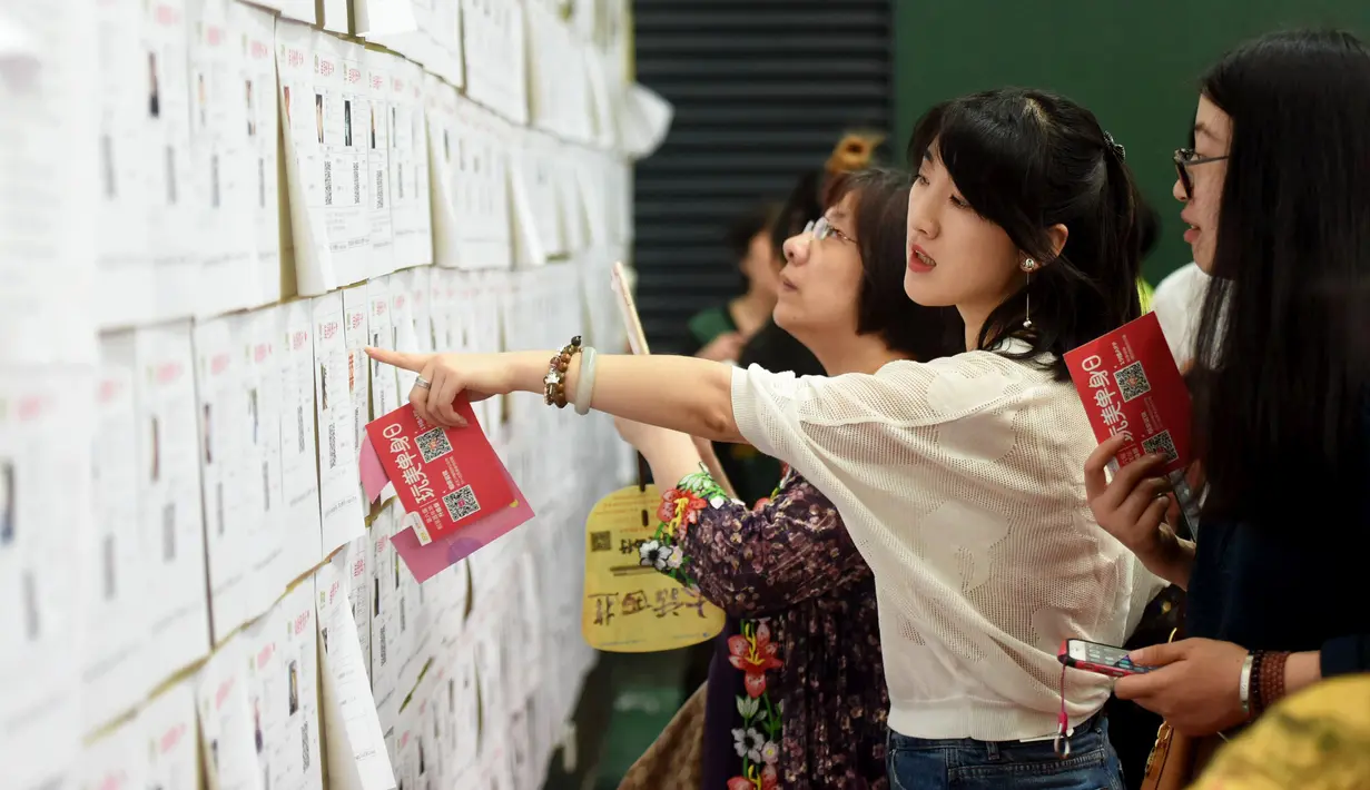 Sejumlah wanita melihat daftar pria lajang saat acara perjodohan di Hangzhou, Provinsi Zhejiang, China (14/5). Para Pria dan wanita mengikuti acara ini dengan harapan mendapatkan pasangan yang sesuai dengan kriterianya. (AFP Photo/Str/China Out)