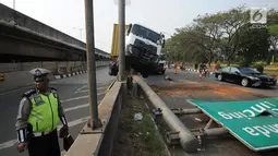 Petugas polisi berada di lokasi kecelakaan kendaraan berat kontainer yang menabrak jalur pembatas pintu masuk tol akses Tanjung Priok di Jalan Raya Cilincing, Jakarta Utara, Sabtu (17/8/2019). (merdeka.com/Arie Basuki)