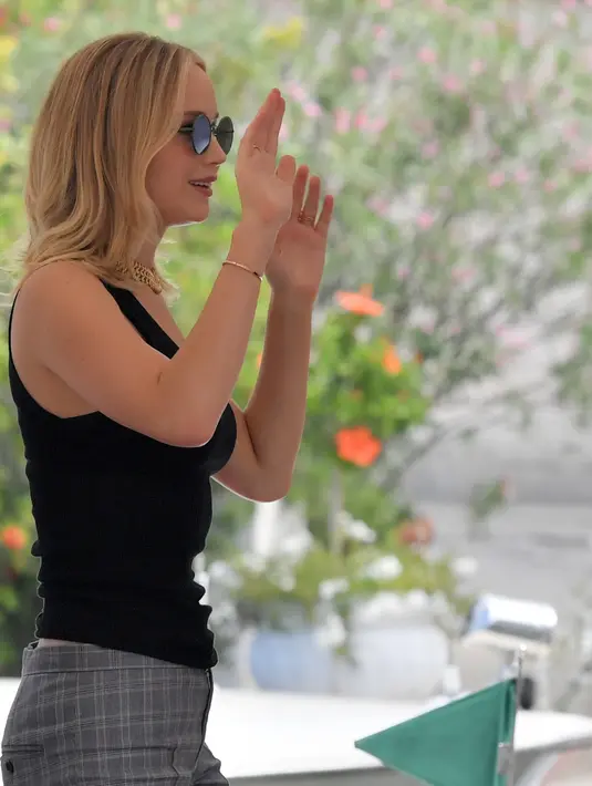 Aktris Jennifer Lawrence menyapa pengemarnya saat tiba di Venice Lido untuk menghadiri Festival Film Internasional Venice ke-74, di Venesia, Italia, (5/9). Jennifer Lawrence tampil cantik mengenakan kacamata dan busana hitam. (Ettore Ferrari/ANSA via AP)