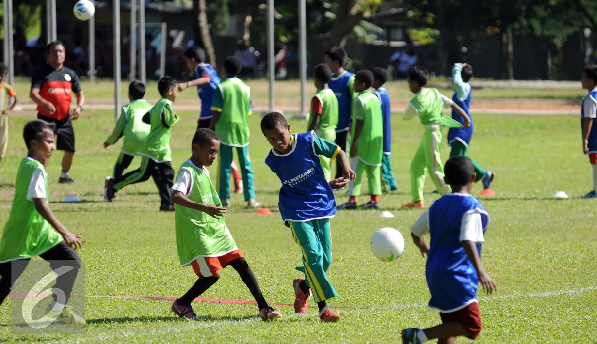 Sejumlah anak bermain bola saat pelatihan singkat di Korem Manokwari, Papua Barat, Selasa (16/8). Jelang perayaan HUT RI ke-71, PT Pertamina mengadakan pelatihan singkat dan laga trofeo di Manokwari. (Liputan6.com/Helmi Fithriansyah)