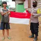 Suku Talang Mamak menerima bendera merah putih yang diberikan personel Polres Indragiri Hulu. (Liputan6.com/M Syukur)