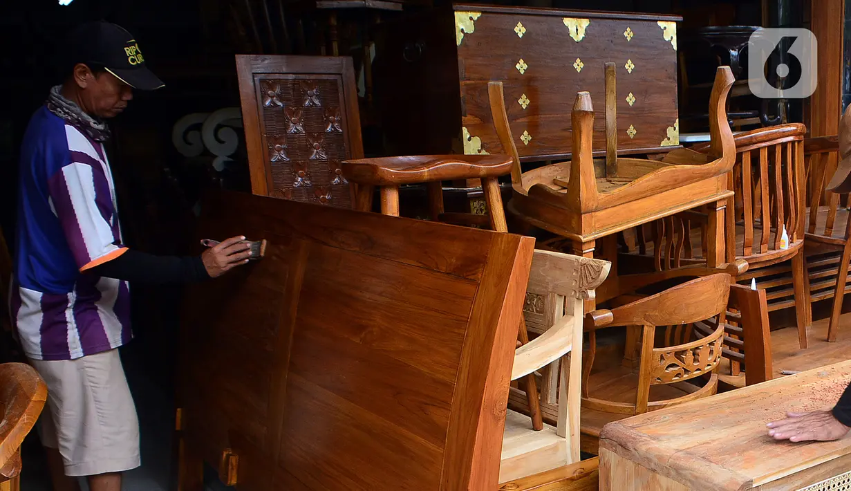 Pekerja melakukan pengecatan pada proses pembuatan furnitur atau perlengkapan rumah berbahan kayu khas Jepara di Ciputat, Tangerang Selatan, Selasa (14/9/2021). Pedagang di tempat tersebut mengakui selama PPKM ini daya beli masyarakat terhadap furnitur meningkat. (Liputan6.com/Johan Tallo)