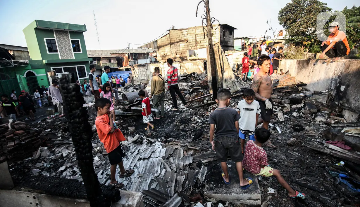 Warga memilah barang yang masih bisa diselamatkan di reruntuhan rumah akibat kebakaran yang melanda pemukiman di jalan Bojong Kavling RT 16/RW04 Kelurahan Rawa Buaya, Jakarta, Rabu (5/1/2022). Kebakaran terjadi Selasa (4/1/2022) menghanguskan setidaknya 14 rumah warga. (Liputan6.com/Johan Tallo)