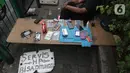 Penjual jasa perbaikan telepon genggam menawarkan jasa di trotoar jalan Mayjen Sutoyo depan Mall Pusat Grosir Cililitan (PGC), Jakarta, Rabu (14/7/2021). Imbas dari penutupan Mall PGC selama PPKM Darurat Jawa-Bali, mereka terpaksa menawarkan jasa di pinggir jalan. (Liputan6.com/Helmi Fithriansyah)