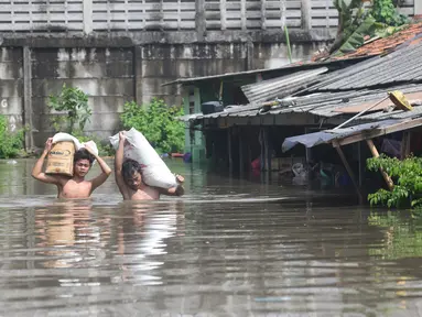 Warga menyelamatkan sagu miliknya saat banjir menggenangi kawasan Kampung Cantiga, Petir, Cipondoh, Kota Tangerang, Banten, Selasa (8/7/2025). (merdeka.com/Arie Basuki)