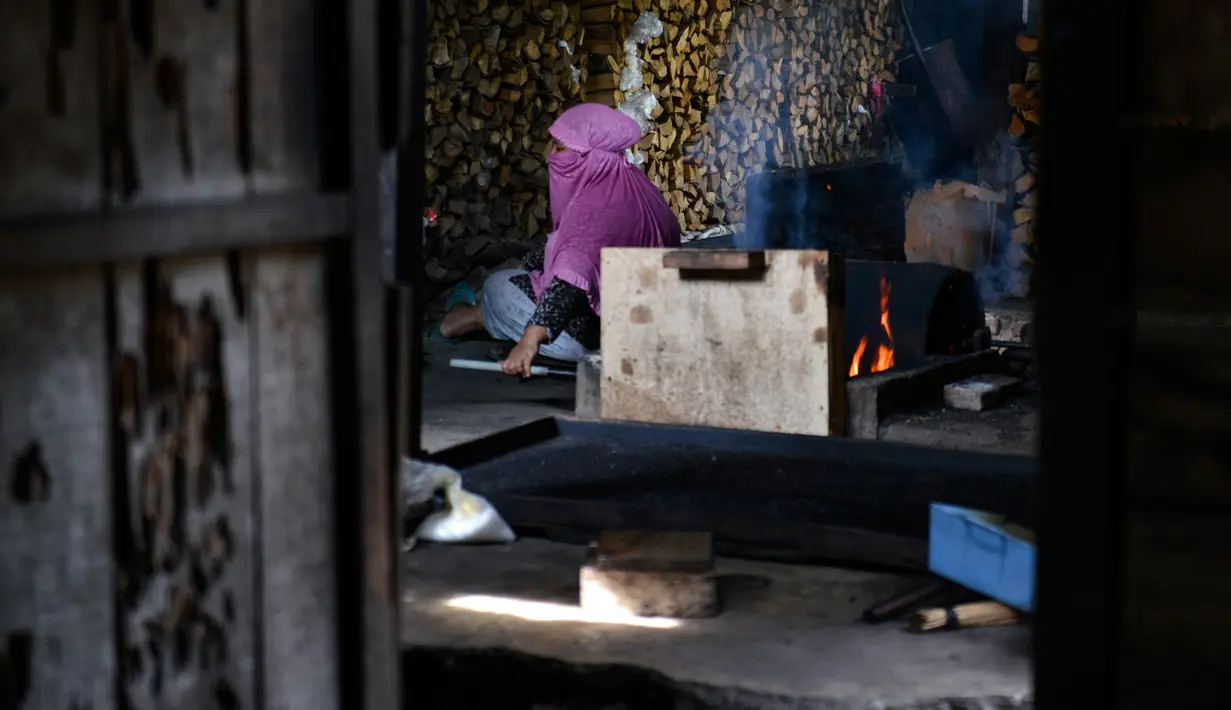 Seorang wanita mengolah biji kopi robusta menggunakan alat tradisional di salah satu industri rumah tangga di Ulee Kareng, Aceh, Rabu (20/11/2019). Kopi yang diolah secara tradisional itu dijual dengan kisaran harga beragam tergantung kualitas. (CHAIDEER MAHYUDDIN/AFP)