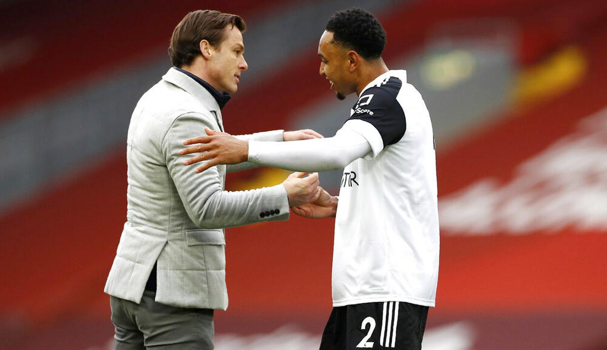 Pelatih Fulham, Scott Parker, melakukan selebrasi bersama Kenny Tete usai berhasil menaklukkan Liverpool pada laga Liga Inggris di Stadion Anfield, Minggu (7/3/2021). Fulham menang dengan skor 0-1. (Phil Noble/Pool via AP)