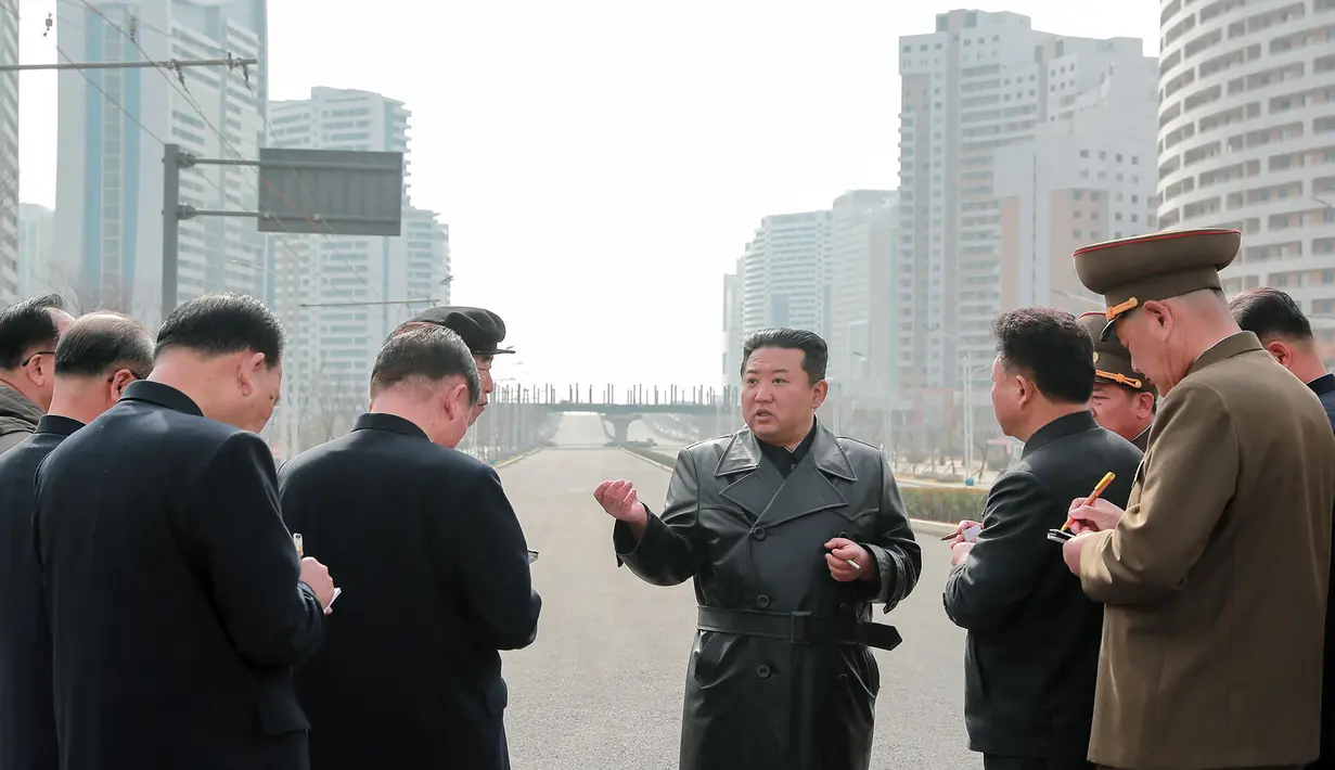 Pemimpin Korea Utara Kim Jong Un (tengah) berbincang dengan para pejabat saat memeriksa lokasi kompleks perumahan 10.000-flat yang sedang dibangun di Pyongyang (16/3/2022). Kim telah menghadiri upacara peletakan batu pertama situs tersebut Maret lalu. (AFP/STR/KCNA Via KNS)