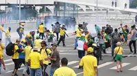 Pendukung mantan Presiden Brasil Jair Bolsonaro bentrok dengan polisi saat demonstrasi di luar Istana Planalto di Brasilia pada Minggu (8/1/2023). (Dok. AFP)&nbsp;