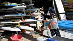 Petugas kesehatan menyemprotkan disinfektan pada papan selancar di sepanjang pantai kawasan wisata Sanur, Bali, Senin (16/3/2020). Penyemprotan dilakukan sebagai salah satu langkah untuk mengantisipasi potensi penyebaran virus Corona COVID-19 di kawasan pariwisata tersebut. (SONNY TUMBELAKA/AFP)