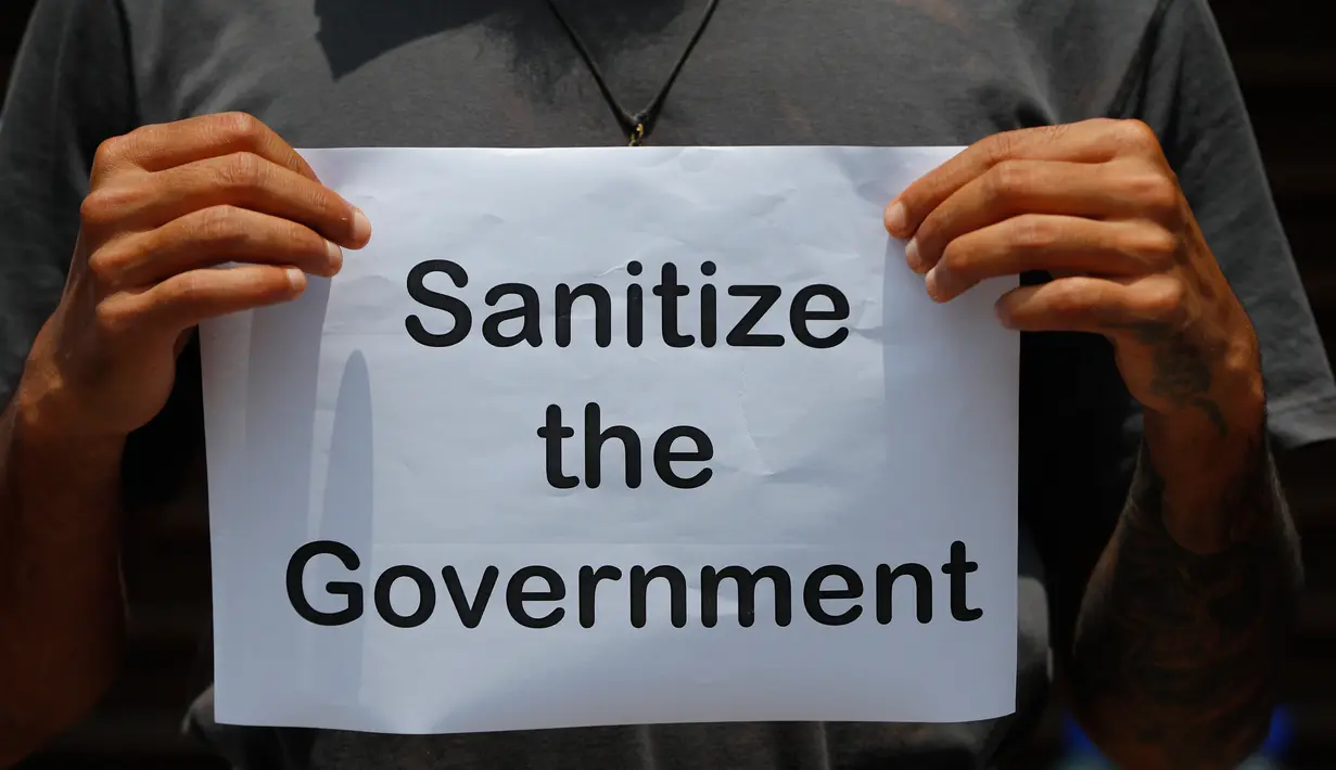 Seorang pemuda Nepal memegang plakat ketika mereka berkumpul untuk melakukan protes di dekat kediaman perdana menteri menuntut penanganan yang lebih baik terhadap pandemi COVID-19 di Kathmandu, Nepal (11/6/2020). (AP Photo/Niranjan Shrestha)