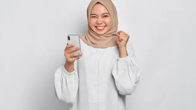 Ilustrasi wanita berhijab memegang smartphone