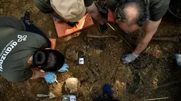 Arkeolog memeriksa kuburan yang diyakini berisi dua tahanan republik yang tewas selama Perang Saudara Spanyol di desa kecil Leranoz, Pyrenees, sekitar 30 km (21,78 mil) dari Pamplona, Spanyol utara, Selasa (22/5). (AP Photo/Alvaro Barrientos)