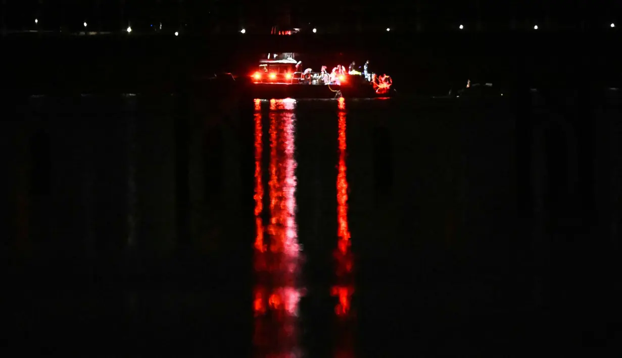 Sebuah kapal berisi tim penyelamat mencari korban di perairan Sungai Potomac, Washington DC, Amerika Serikat (AS), 30 Januari 2025. (ANDREW CABALLERO-REYNOLDS/AFP)