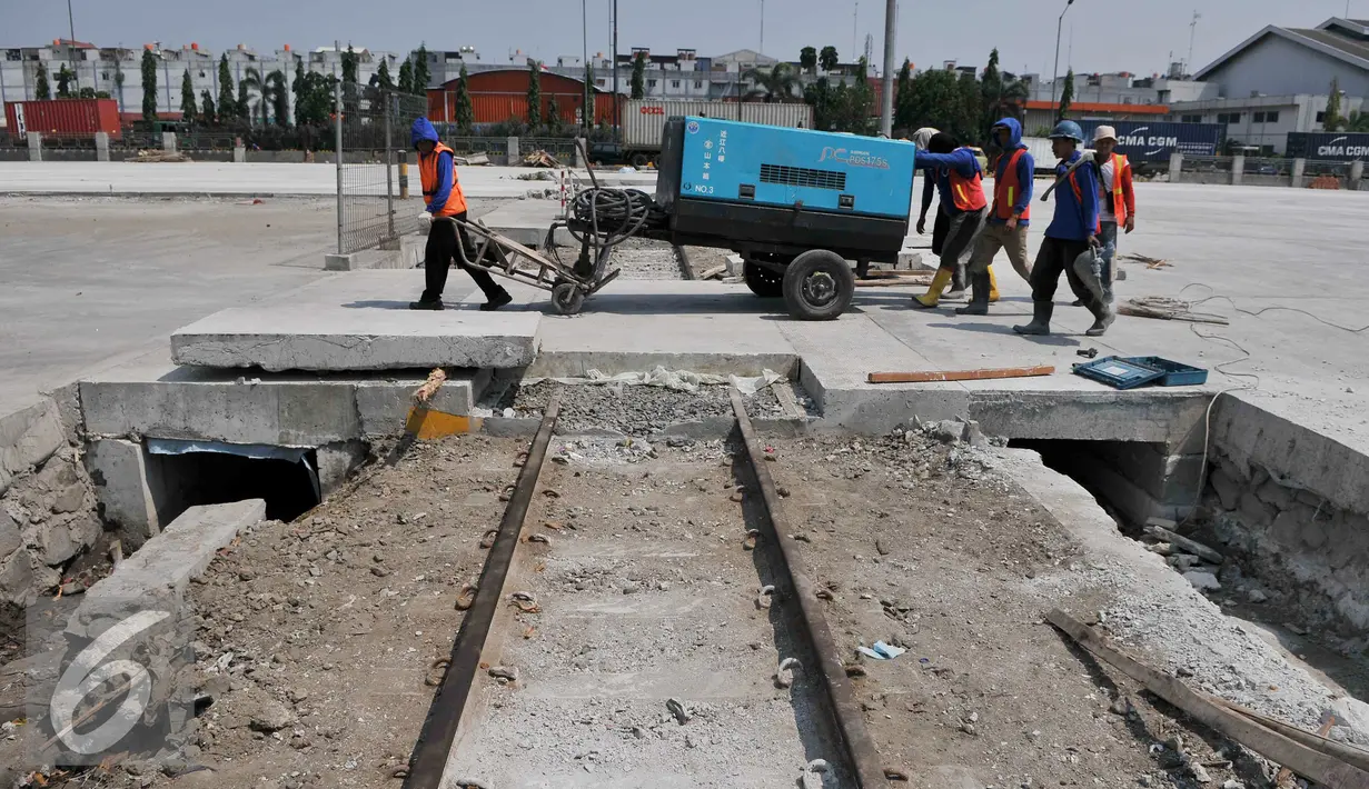 Pekerja membawa mesin disel saat pembongkaran beton rel kereta utama di Pelabuhan Tanjung Priok, Jakarta, Jumat (11/9/2015). Penutupan jalur kereta oleh Pelindo II membuat tidak efisiensi waktu bongkar pasang. (Liputan6.com/Gempur M Surya)