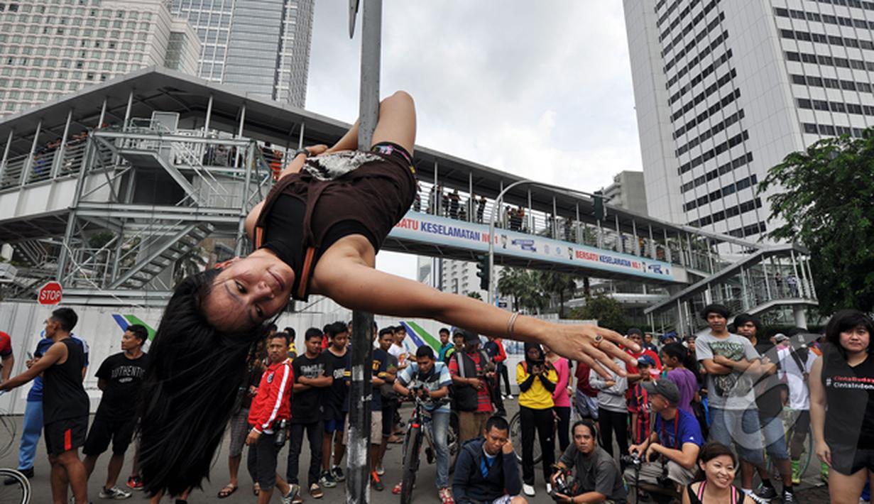  'Pole Dance' yang memiliki cap sebagai tarian erotis diperkenalkan sebagai alternatif latihan fisik untuk menjaga kebugaran tubuh dan kekuatan otot, Bundaran HI, Jakarta, Minggu (18/1/2015). (Liputan6.com/Miftahul Hayat)