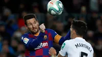 Striker Barcelona, Lionel Messi melompat saat berebut bola dengan pemain Granada, Jose Antonio Martinez pada lanjutan pertandingan La Liga Spanyol di Camp Nou, Minggu (19/1/2020). Messi tampil menjadi pahlawan kemenangan Barcelona yang mencetak satu-satunya gol di laga tersebut. (AP/Joan Monfort)