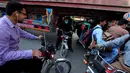 Sejumlah pengendara motor melewati kolong sebuah truk kontainer di Rawalpindi, Pakistan (28/10). Tanpa rasa takut para pengendara motor tersebut melintasi kolong truk yang membawa peti kemas. (Reuters/Faisal Mahmood)