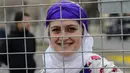 Seorang wanita berpose di belakang pagar polisi saat memperingati Women's Day atau Hari Perempuan Internasional di Diyarbakir, Turki, Kamis (8/3). (ILYAS AKENGIN/AFP)