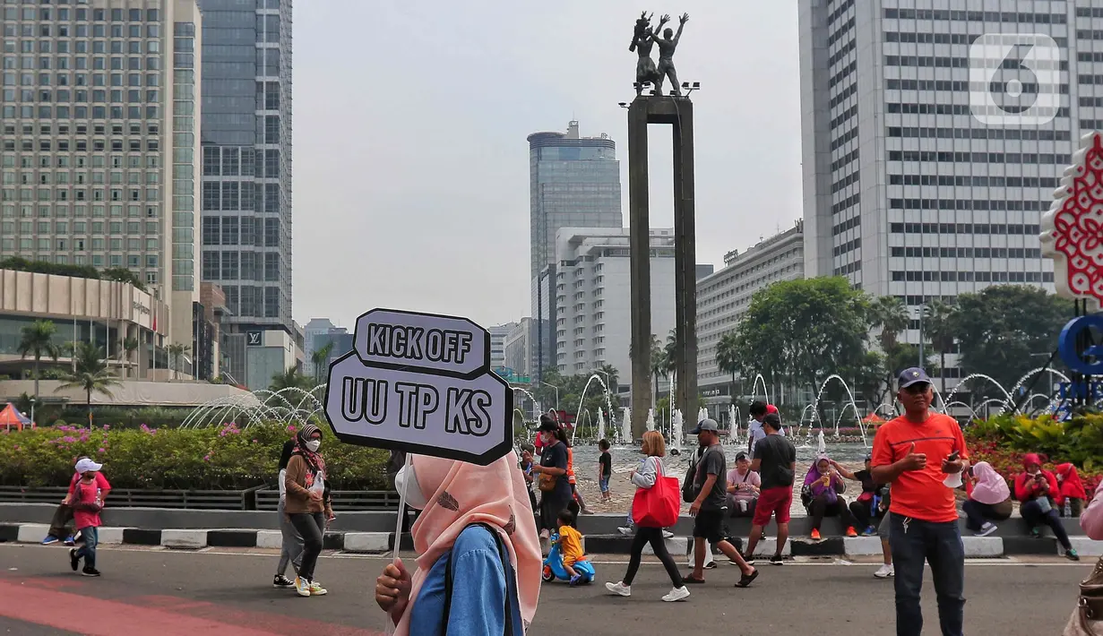 Masyarakat membawa poster sosialisasi UU TPKS saat Car Free Day di kawasan Bundaran HI, Jakarta, Minggu (25/9/2022). Kampanye Undang-undang Tindak Pelaku Kekerasan Seksual (UU TPKS)  tersebut dilakukan agar masayarakat dapat mengetahui UU ini menjadi payung hukum bagi korban kekerasan seksual. Bukan hanya korban yang bisa melaporkan tindak kekerasan seksual, tapi bagi yang mendengar atau melihat juga bisa melaporkan. (Liputan6.com/Angga Yuniar)