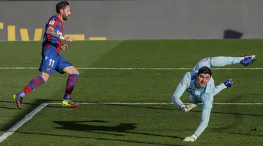 Pemain Levante Jose Luis Morales (kiri) mencetak gol ke gawang Real Madrid yang dijaga Thibaut Courtois pada pertandingan Liga Spanyol di Stadion Alfredo Di Stefano, Madrid, Spanyol, Sabtu (30/1/2021). Real Madrid kalah 1-2. (AP Photo/Manu Fernandez)