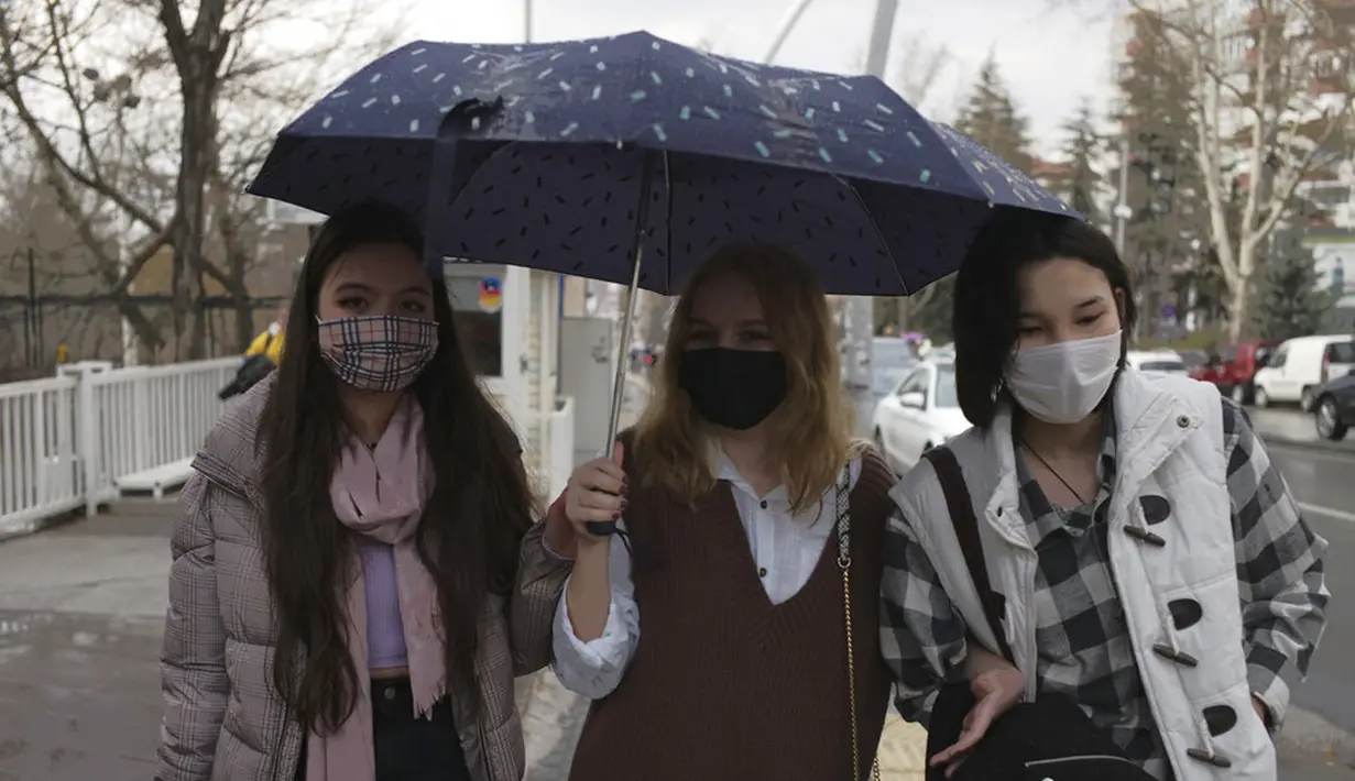 Orang-orang yang memakai masker untuk membantu melindungi dari penyebaran COVID-19 berjalan di Ankara, Turki, Senin (29/3/2021). Turki kembali memberlakukan lockdown akhir pekan dan pembatasan selama Ramadan menyusul peningkatan tajam kasus COVID-19. (AP Photo/Burhan Ozbilici)