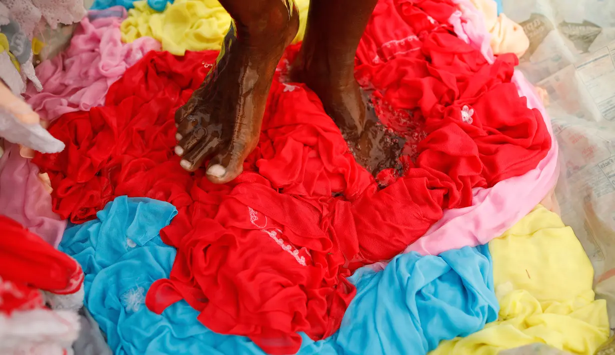 Dhobi, atau tukang cuci mencuci kain di tepi Sungai Gomti di Lucknow, 12 September 2020. Pekerjaan yang telah ada selama beberapa generasi  ini masih populer di India, meskipun ada teknologi modern dengan penghasilan setiap keluarga sekitar 100-200 dollar AS per bulan. (AP Photo/Rajesh Kumar Singh)