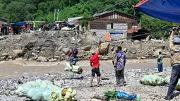 Hingga awal Januari 2026, warga Kecamatan Ketol di Aceh Tengah belum bisa menikmati akses jalan yang layak. Tampak dalam foto, warga menggunakan tali untuk menyeberangi sungai setelah banjir bandang yang menghancurkan desa-desa di sekitarnya di Ketol, provinsi Aceh, pada Selasa 6 Januari 2026. (CHAIDEER MAHYUDDIN/AFP)